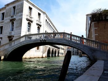 Bridge over river in city against sky