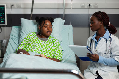 Portrait of female doctor examining patient in hospital