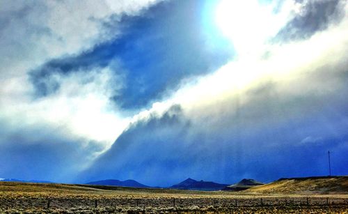 Scenic view of field against cloudy sky