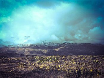 Scenic view of mountains against cloudy sky