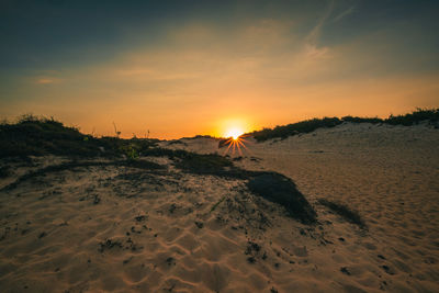 Scenic view of beach against sky during sunset