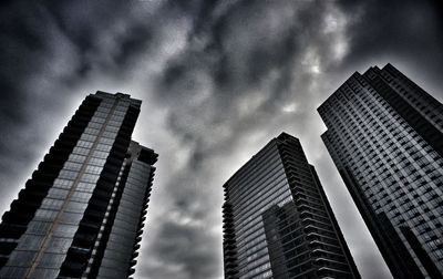 Low angle view of modern building against cloudy sky