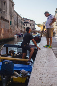 People working on boat against sky