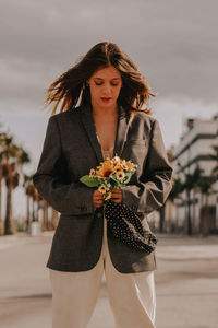 Portrait of a beautiful young woman standing against white wall