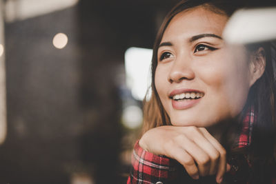 Close-up of smiling young woman looking away