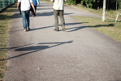 Low section of people walking on skateboard