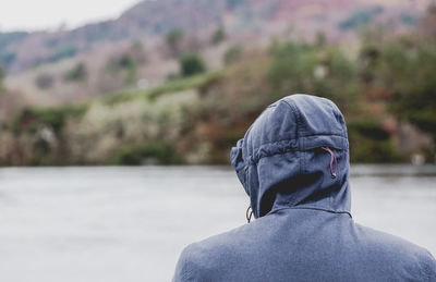 Rear view of man against lake