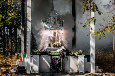 View of statue against trees and temple