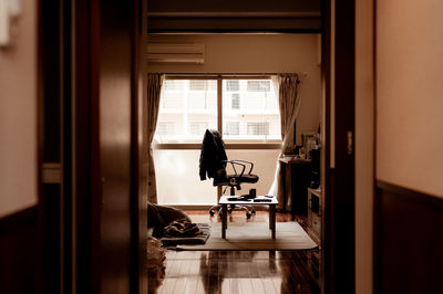 Woman standing by window at home