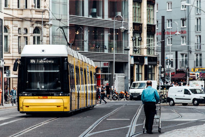 Vehicles on road against buildings in city