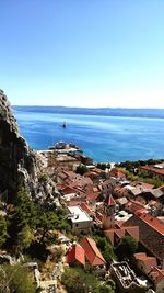 High angle view of townscape by sea against sky