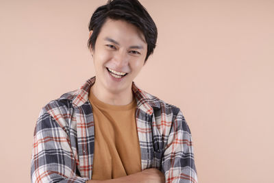 Portrait of a smiling young man against gray background