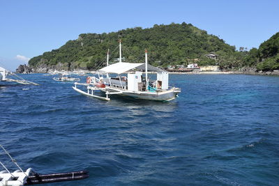 Boat sailing in sea against clear sky