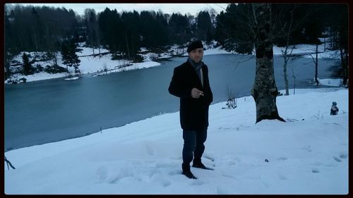 Full length of man standing on snow covered field