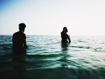 Silhouette man in swimming pool against sea