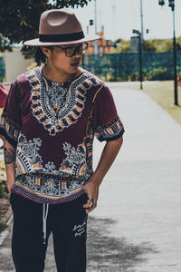 Midsection of young man looking away in city