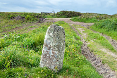 Stone wall on field against sky