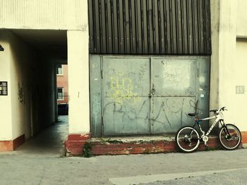 Bicycle parked against wall in city