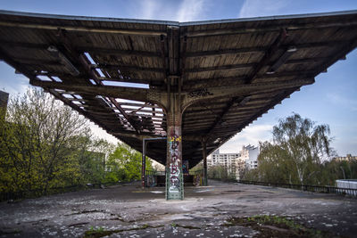 Low angle view of bridge amidst buildings against sky