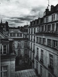 Buildings in city against cloudy sky