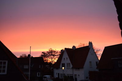 Silhouette buildings against sky at sunset