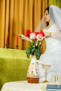 Woman with red flowers on table