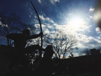 Low angle view of silhouette man against trees