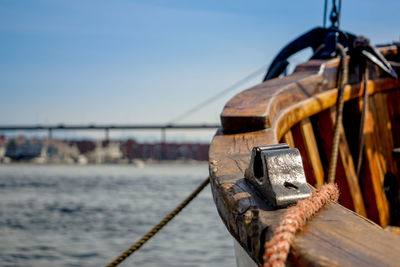 Close-up of rope on wooden post by sea against sky