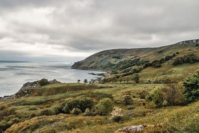 Scenic view of sea and mountains against sky