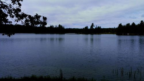 Scenic view of lake against cloudy sky