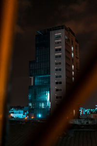 Low angle view of illuminated buildings against sky at night