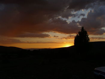 Silhouette of landscape against cloudy sky