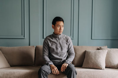 Young woman sitting on sofa at home