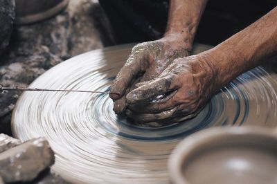 High angle view of cropped hands making clay pots