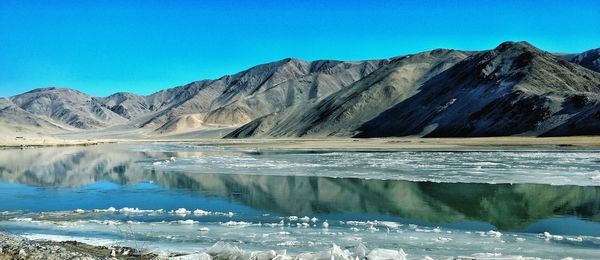 Scenic view of mountains against clear blue sky