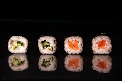 Close-up of sushi against black background