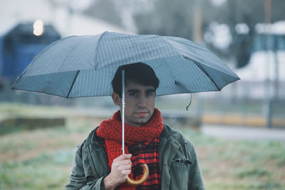 Portrait of young man drinking outdoors