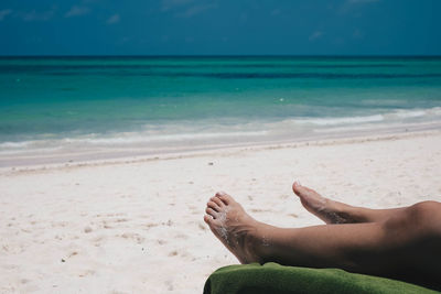 Low section of person relaxing at beach