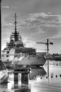 Ship in river against sky at harbor