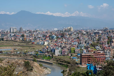 High angle view of buildings and mountains against sky