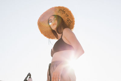 Rear view of woman wearing hat against clear sky