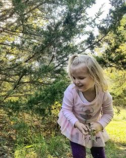 Girl smiling against trees