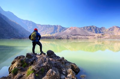 Man looking at lake against mountain range