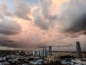 View of cityscape against cloudy sky