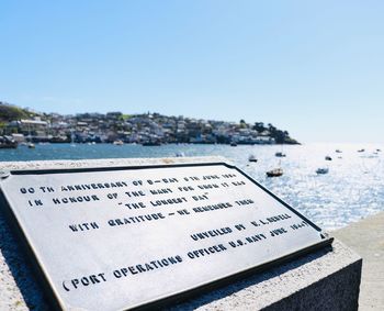 Close-up of text on beach against clear sky