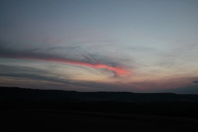 Scenic view of dramatic sky over silhouette landscape