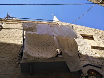 Low angle view of clothes drying against sky