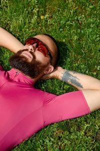 Low section of woman lying on grassy field