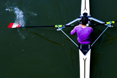 Rear view of person holding umbrella in river