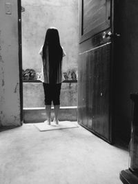 Rear view of girl standing at doorway